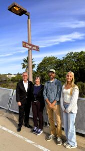 Council President LaCava along with Friends of Rose Creek's Karin Zirk, San Diego Bird Alliance's Andrew Meyer and Interact Club's Elise Liljenstrand-Mjoen under the sign on the Mike Gotch Bridge.